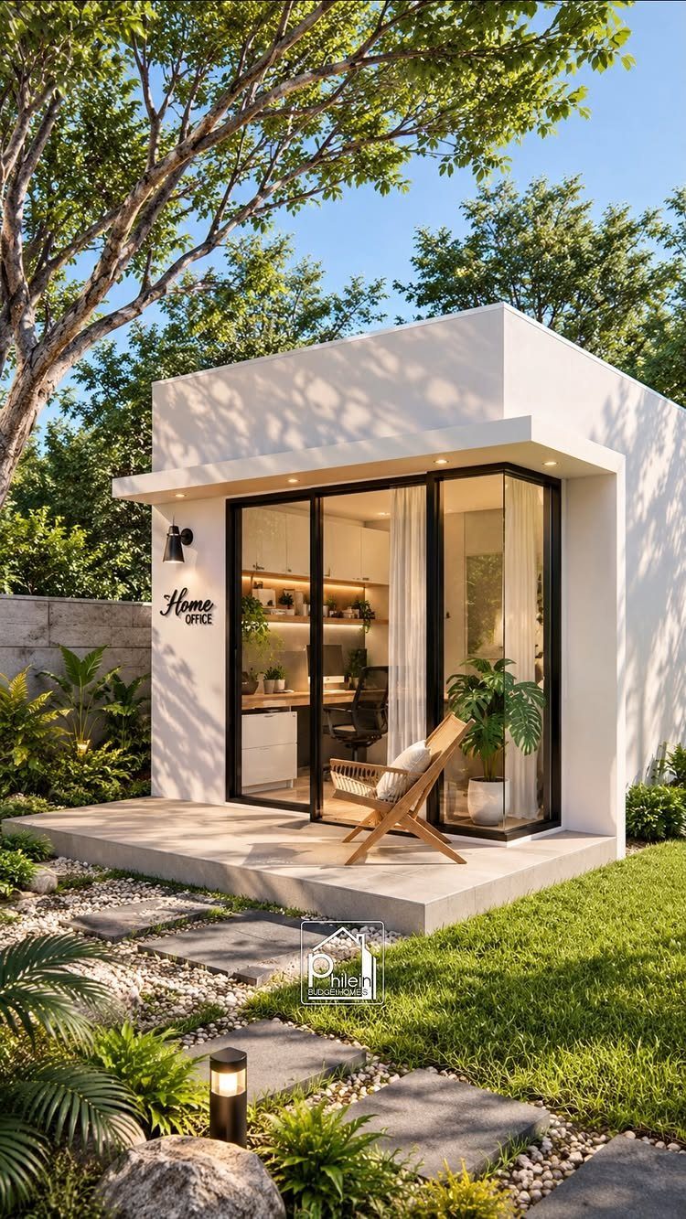 Modern white backyard office pod with glass walls and a concrete patio.