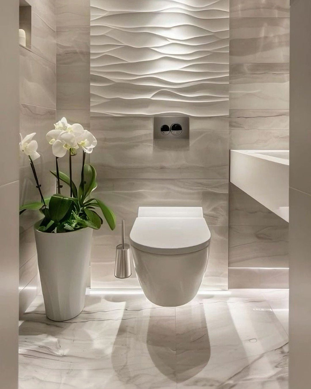 Wall-hung toilet with concealed cistern in a white marble bathroom with orchids.