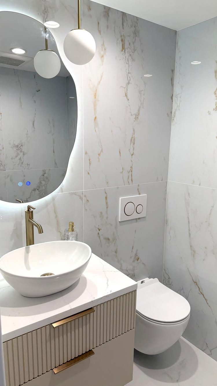 Large white marble tiles on walls of a modern small bathroom with vessel sink.