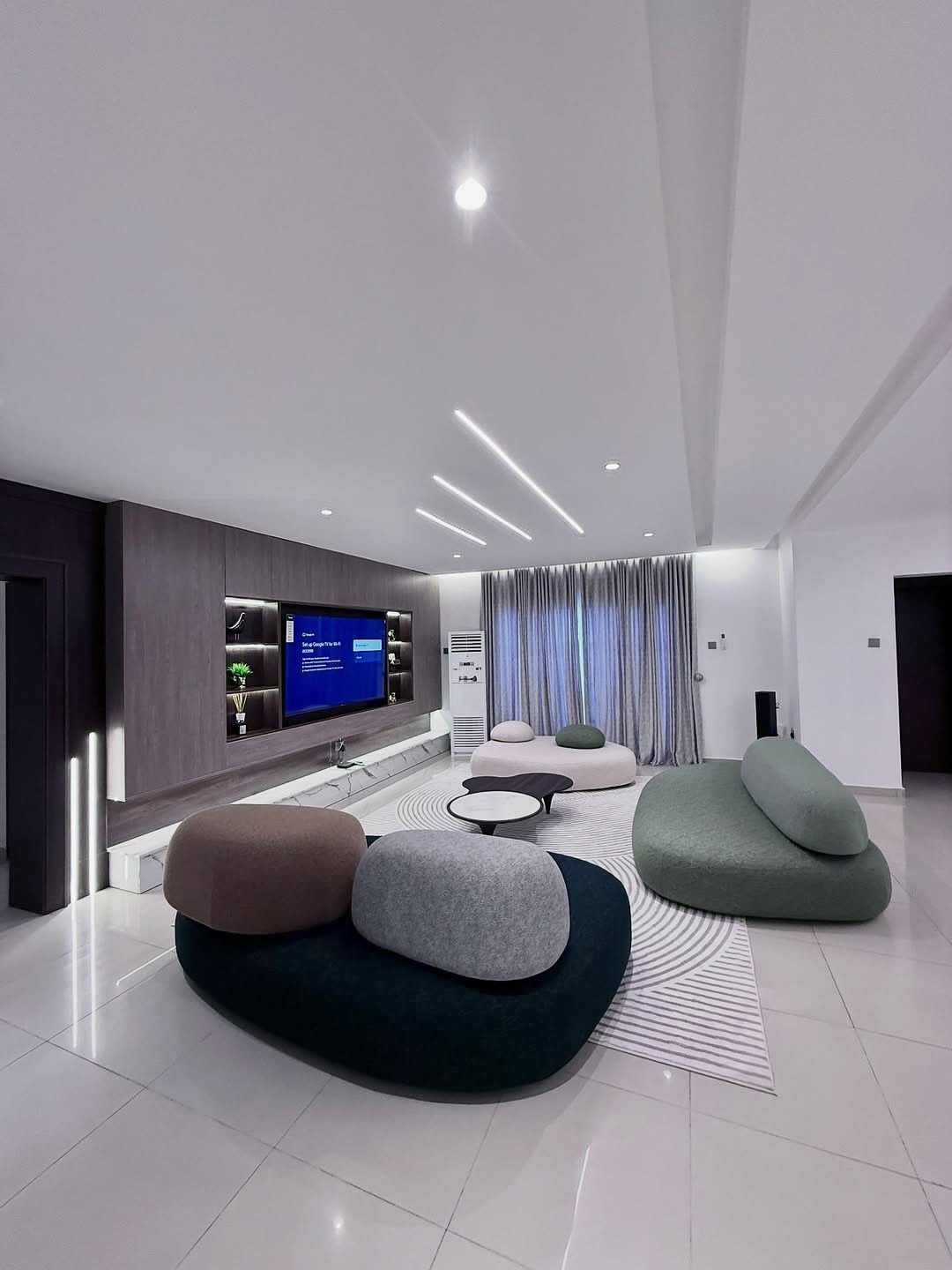 Modern living room with organic modular sofas and a built-in TV wall unit.