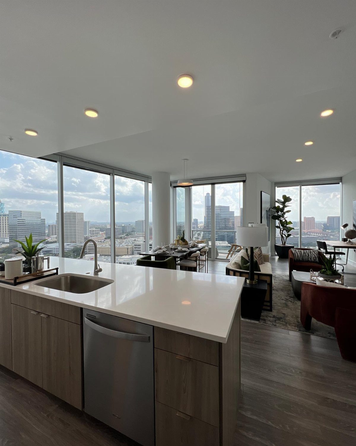 Modern apartment interior with floor-to-ceiling windows overlooking a dense city skyline.