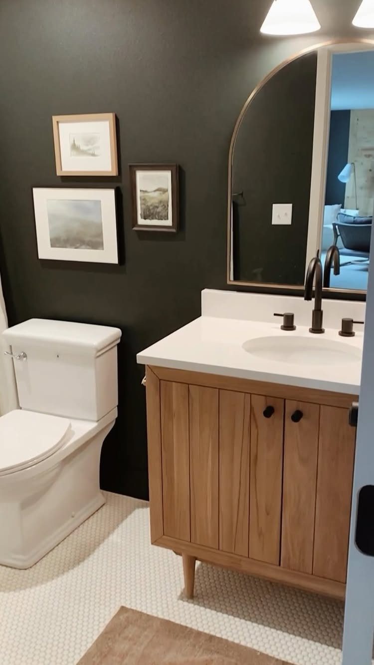 Dark gray bathroom walls with a light wood vanity and white sink.