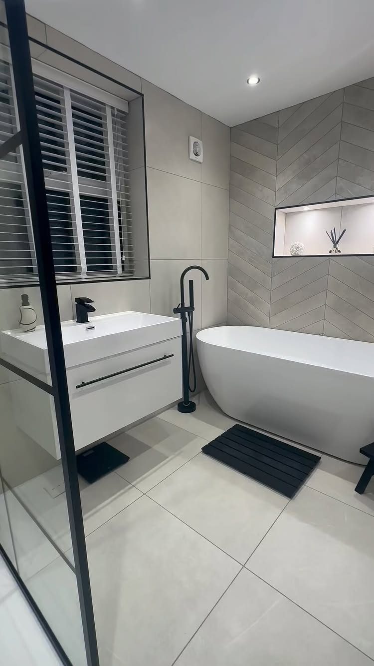 White freestanding bathtub and floating vanity in a modern grey and white bathroom