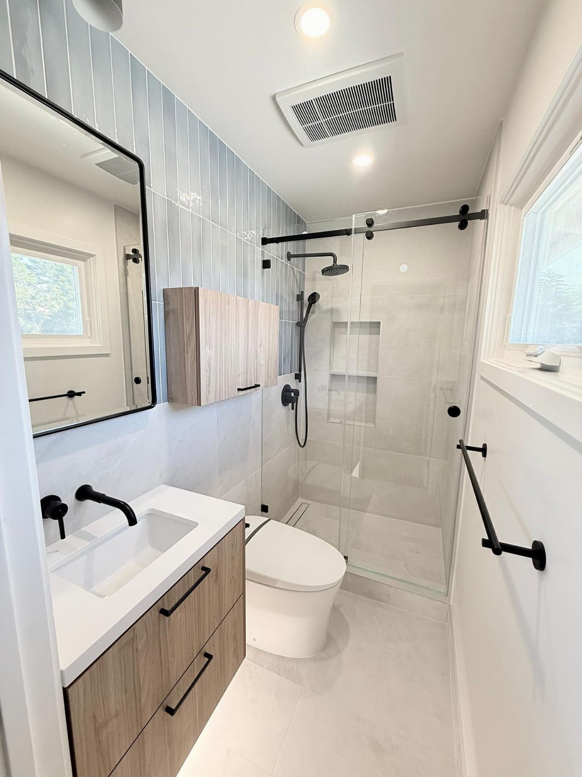 Modern bathroom with white marble-look tiles in the shower and on the floor.