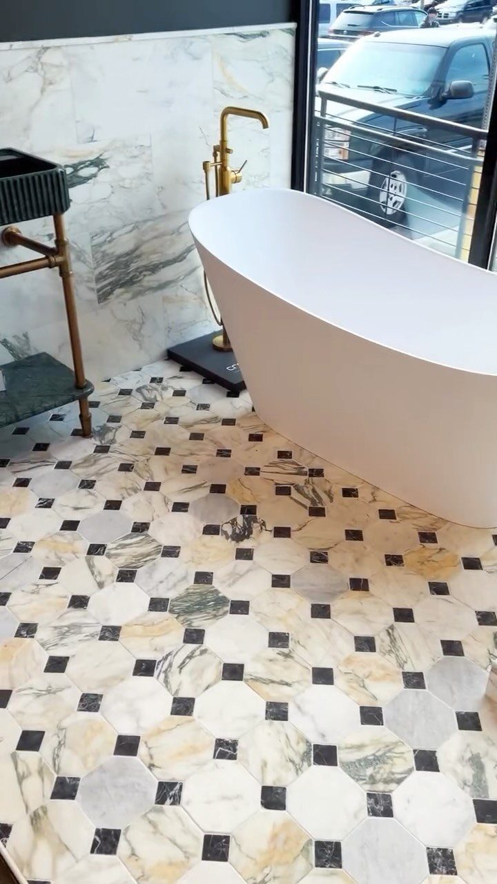 Octagonal marble floor tiles in a bathroom with a white freestanding bathtub.