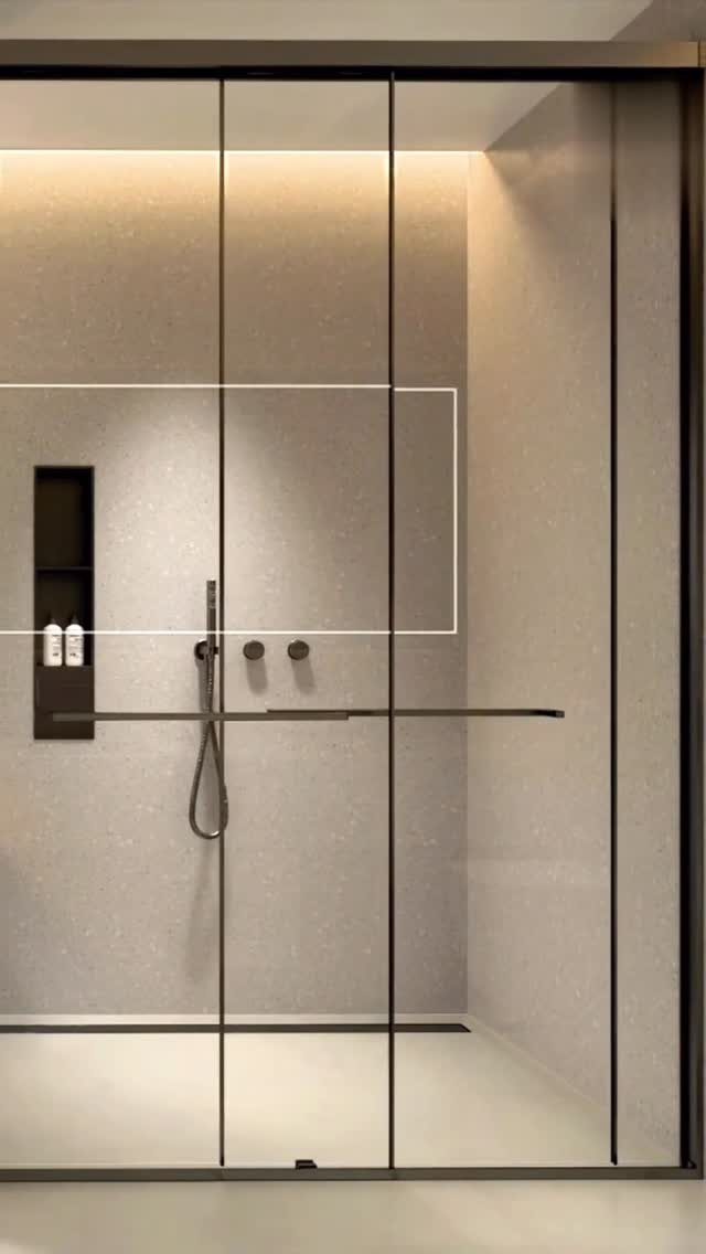 Black framed glass shower panels in a modern bathroom with beige stone walls.