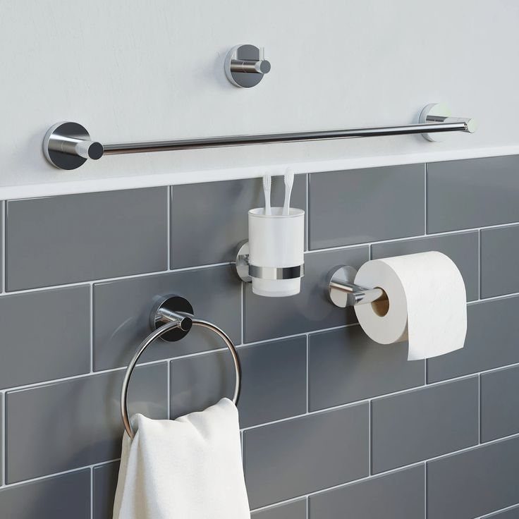 Chrome bathroom fixtures mounted on grey subway tiles and a white wall.