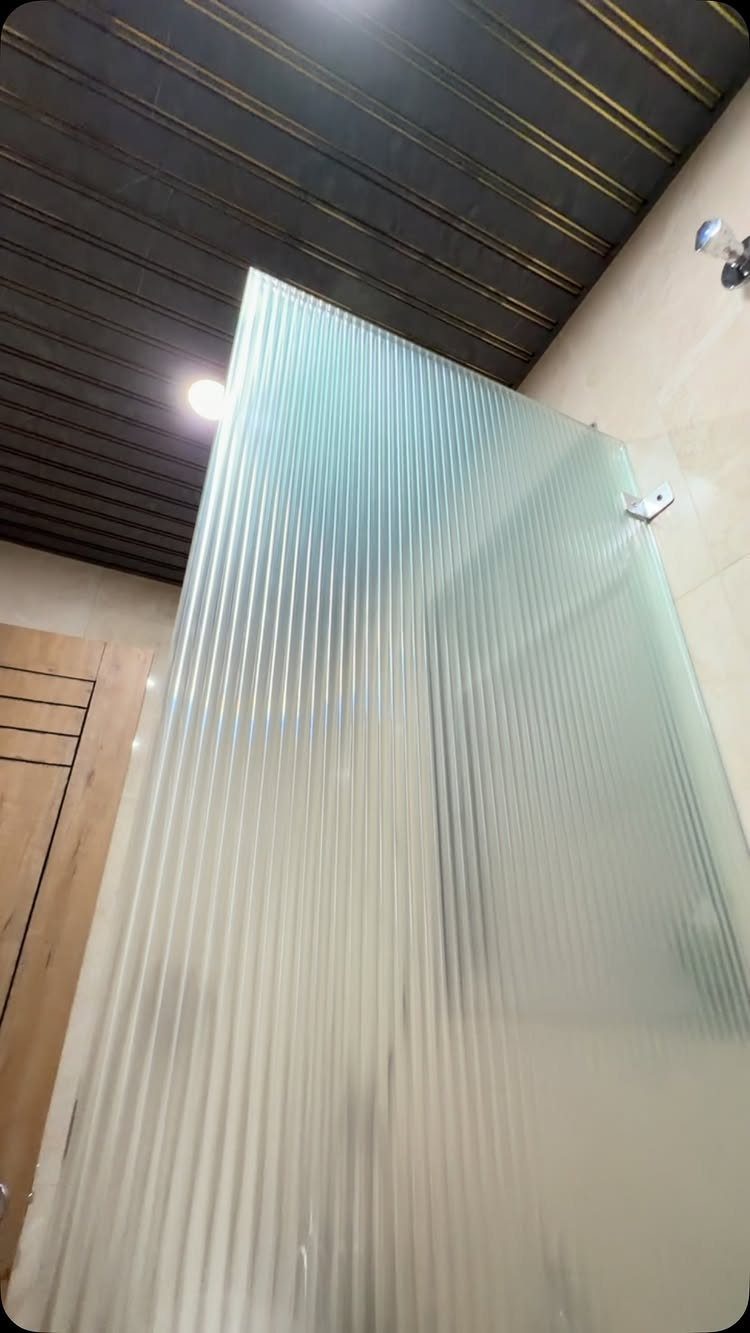 Fluted translucent glass shower partition with a ribbed texture in a modern bathroom.
