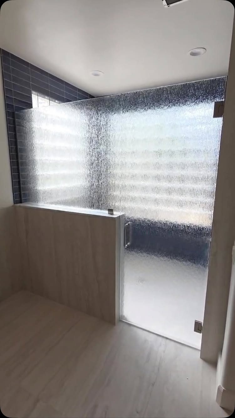 Rain glass shower door with textured surface in a modern bathroom setting.