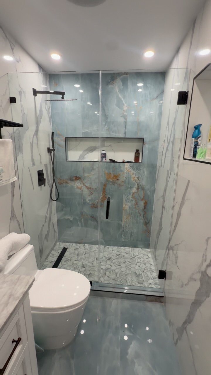 Modern bathroom with light blue marbled glass tiles on walls and floor