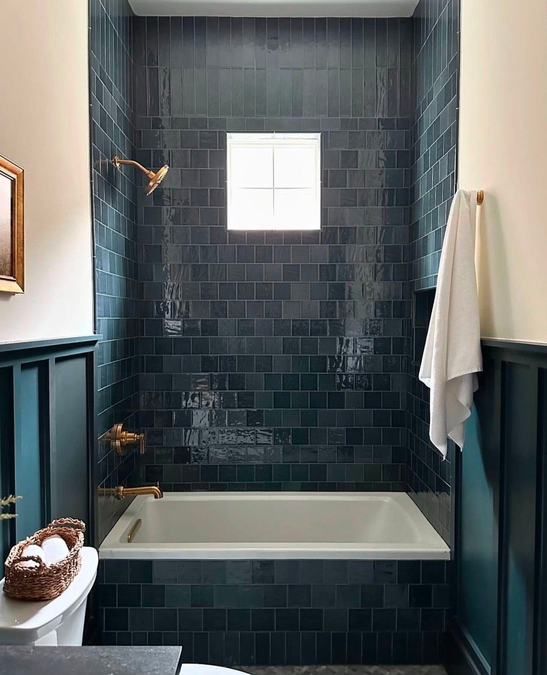 Dark teal glossy subway tiles lining a bathroom shower and bathtub surround.