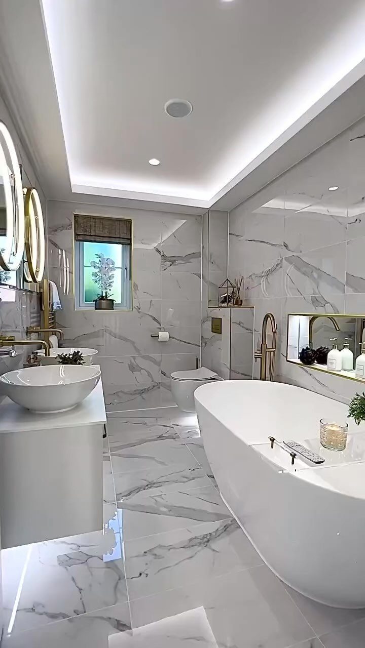 Modern bathroom with white marble tiles on walls and floor and freestanding tub