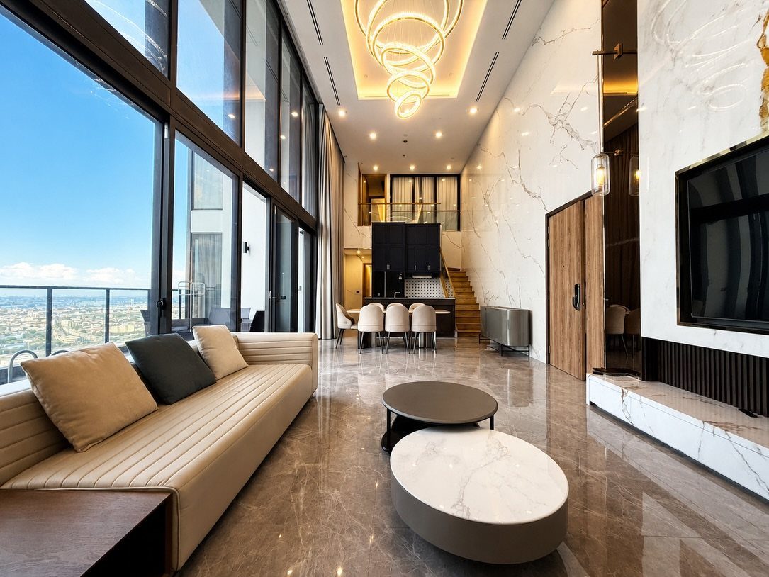 Luxury modern living room with marble floors and floor-to-ceiling city view windows.