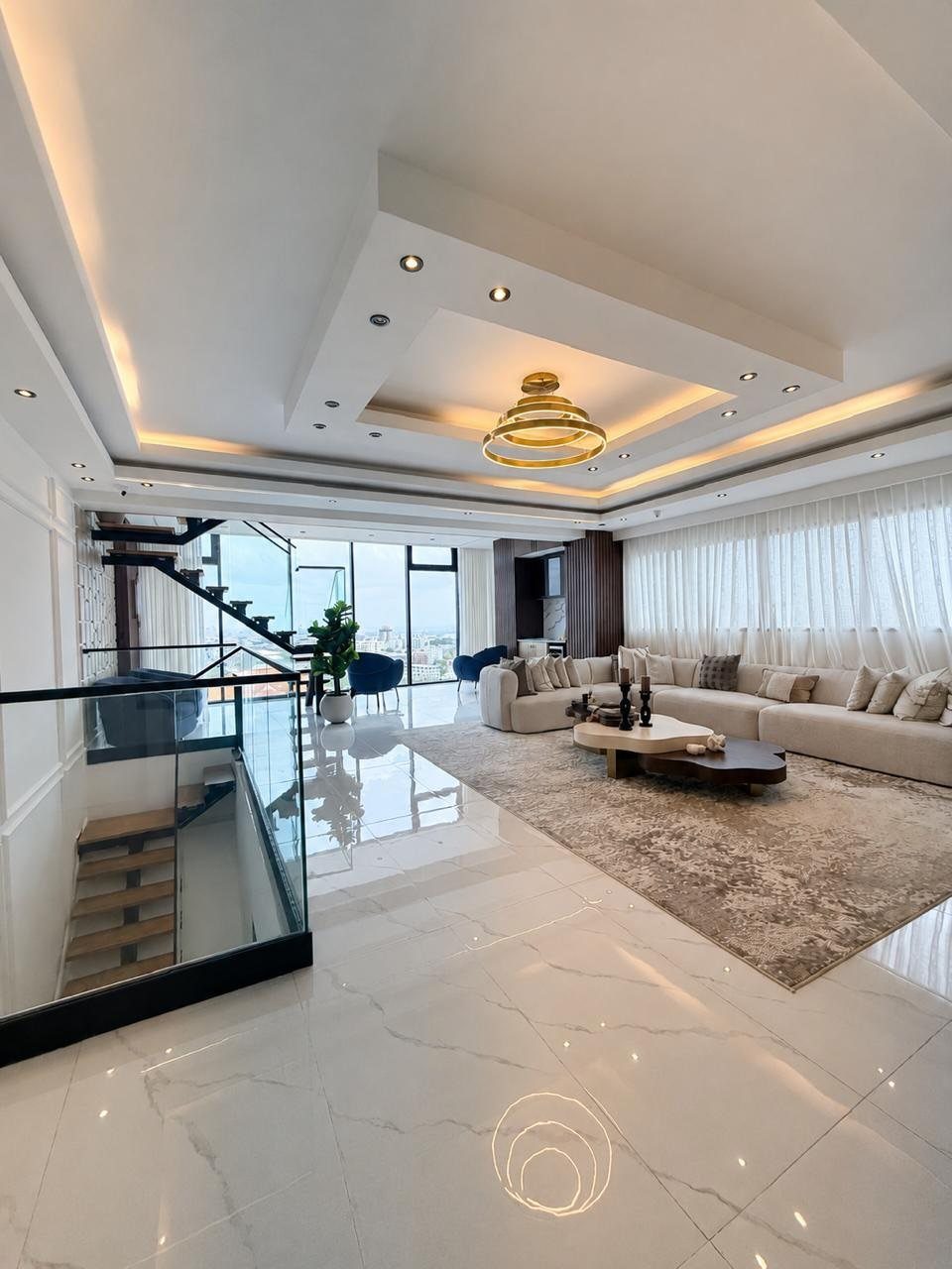 Modern luxury penthouse living room with white marble floors and city views.
