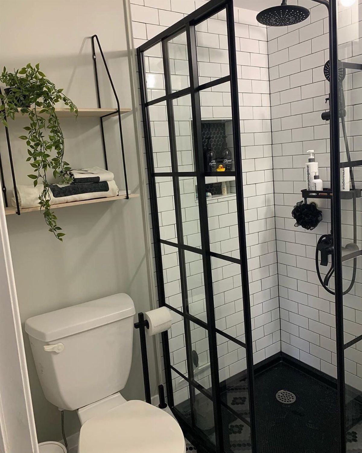 Modern bathroom with white subway tiles, black shower frame, and white toilet.