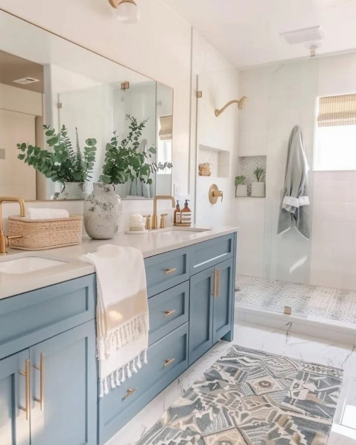 Light blue bathroom vanity with gold hardware and a grey patterned floor rug.