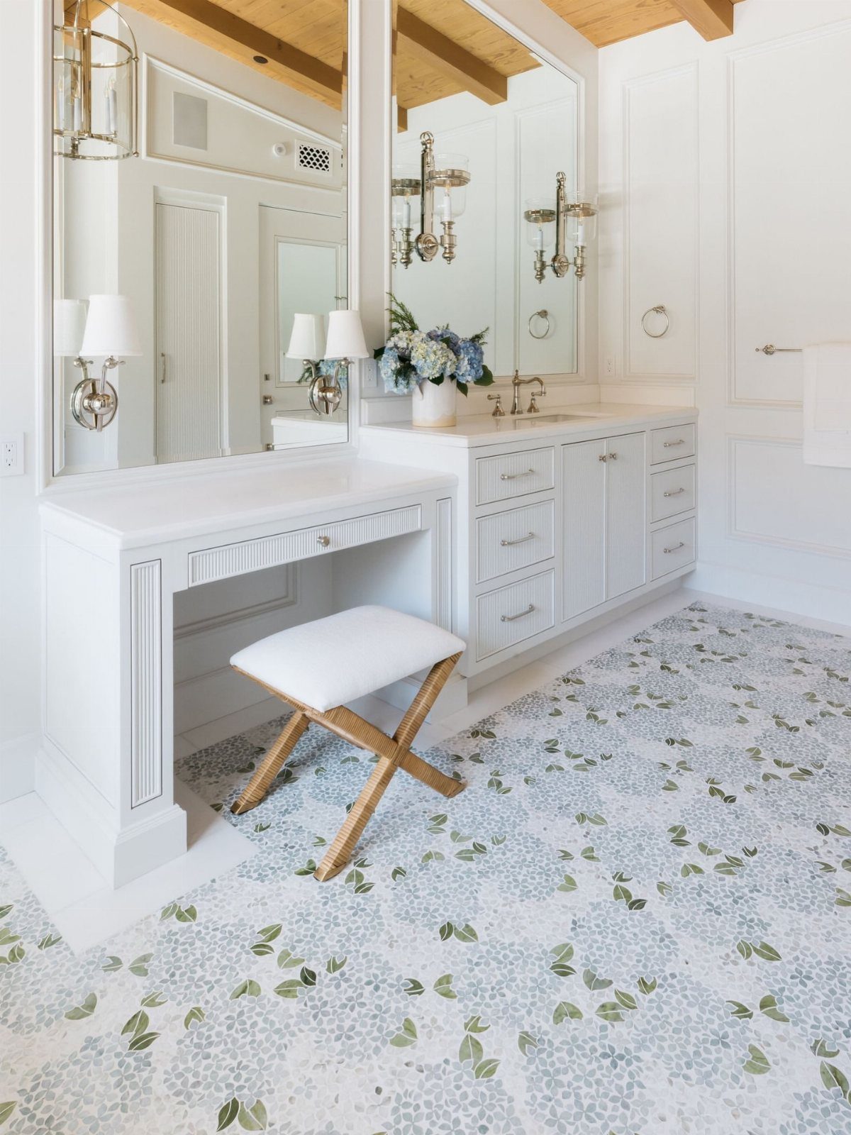 White bathroom vanity with a makeup desk and floral patterned flooring.