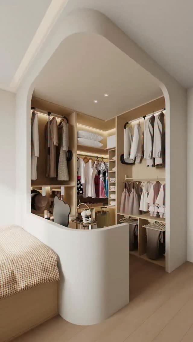 Built-in walk-in closet area with light wood shelving and hanging clothes in bedroom