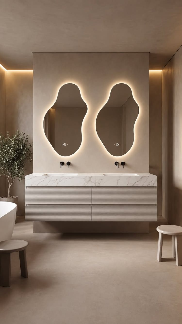 Floating double sink bathroom vanity with marble top and organic backlit mirrors.