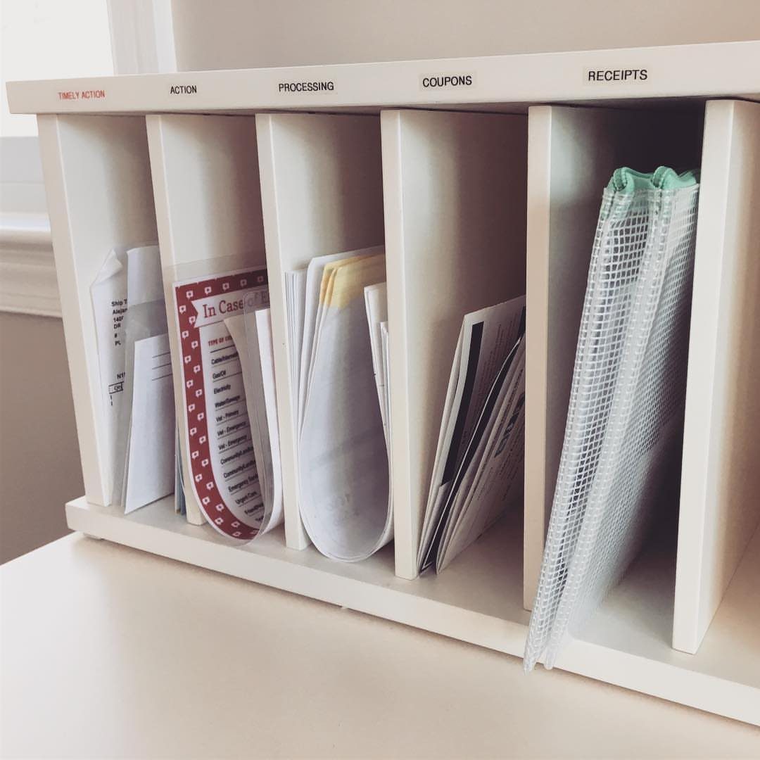 White desk organizer with labeled slots holding mail, coupons, and receipts.
