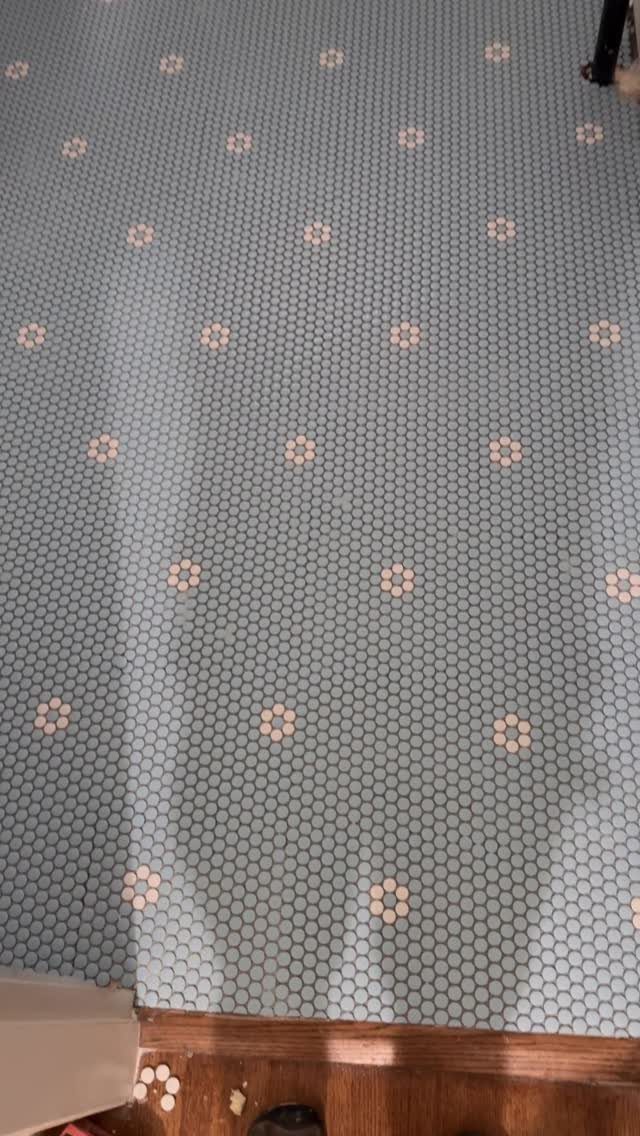 Light blue hexagonal mosaic floor tiles with small white and beige floral patterns.