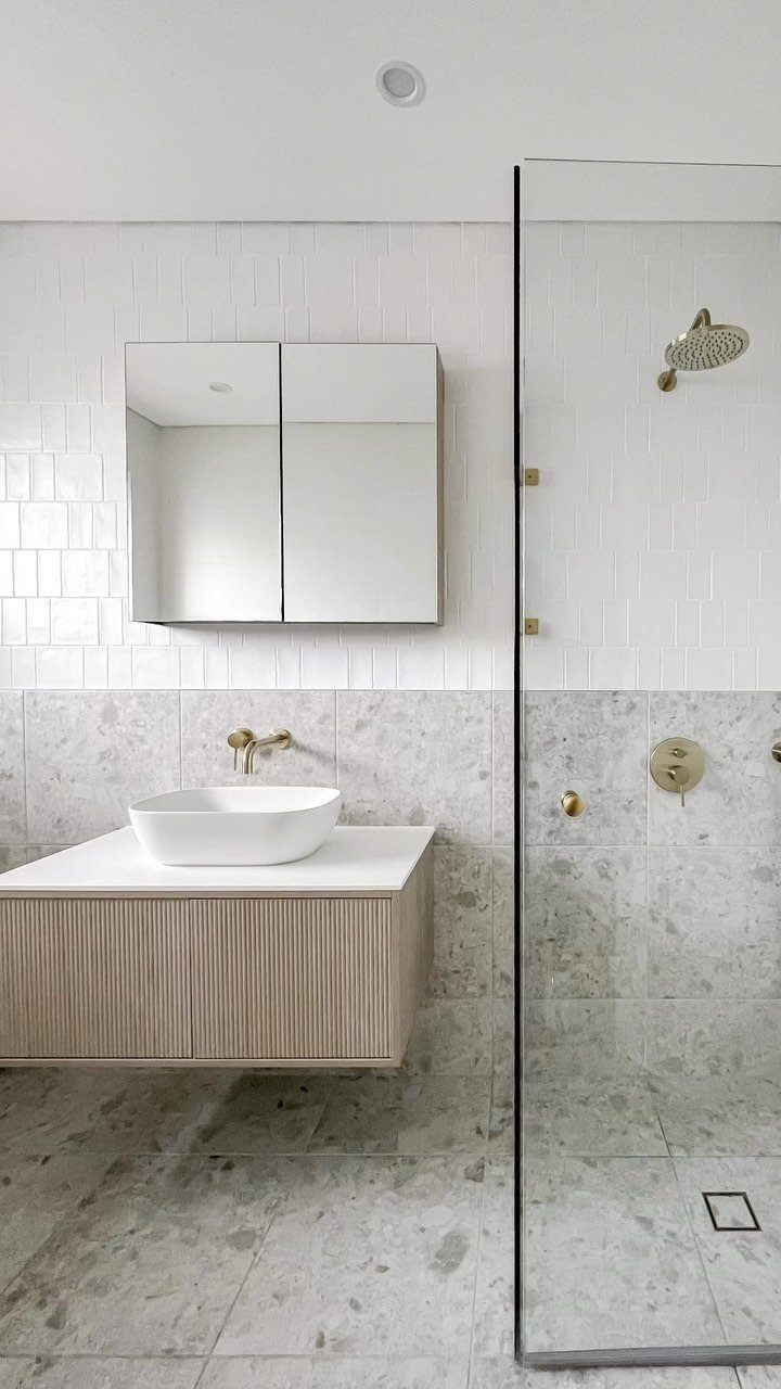 Grey marble floor tiles in a modern bathroom with white subway wall tiles.