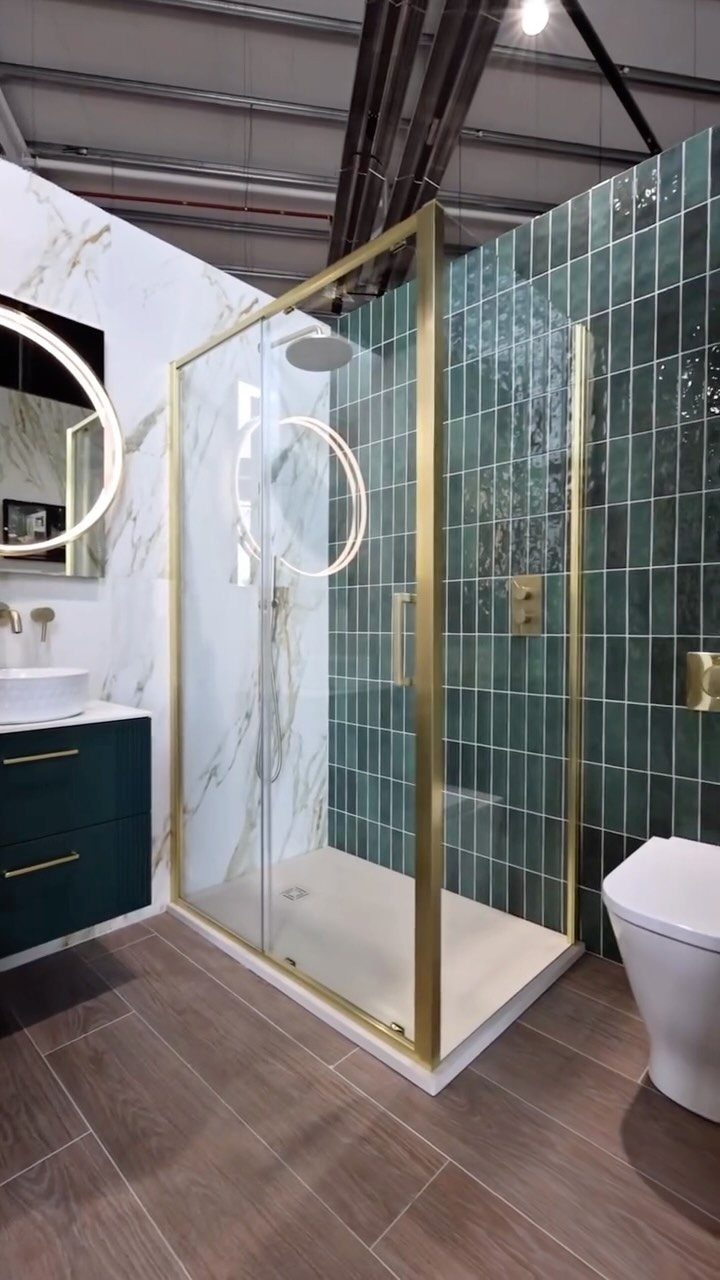 Brown wood-look floor tiles in a bathroom with teal wall tiles and gold accents.
