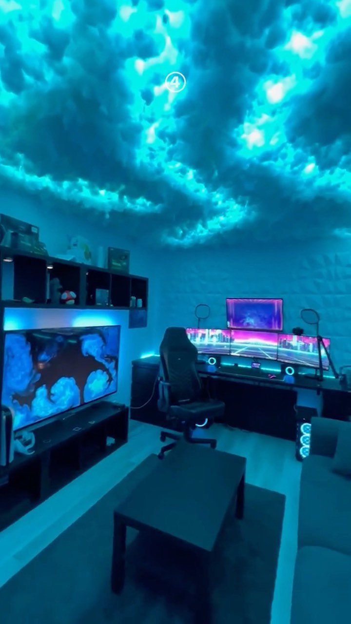 Gaming room with blue LED cloud ceiling, multiple monitors, and a gaming chair.