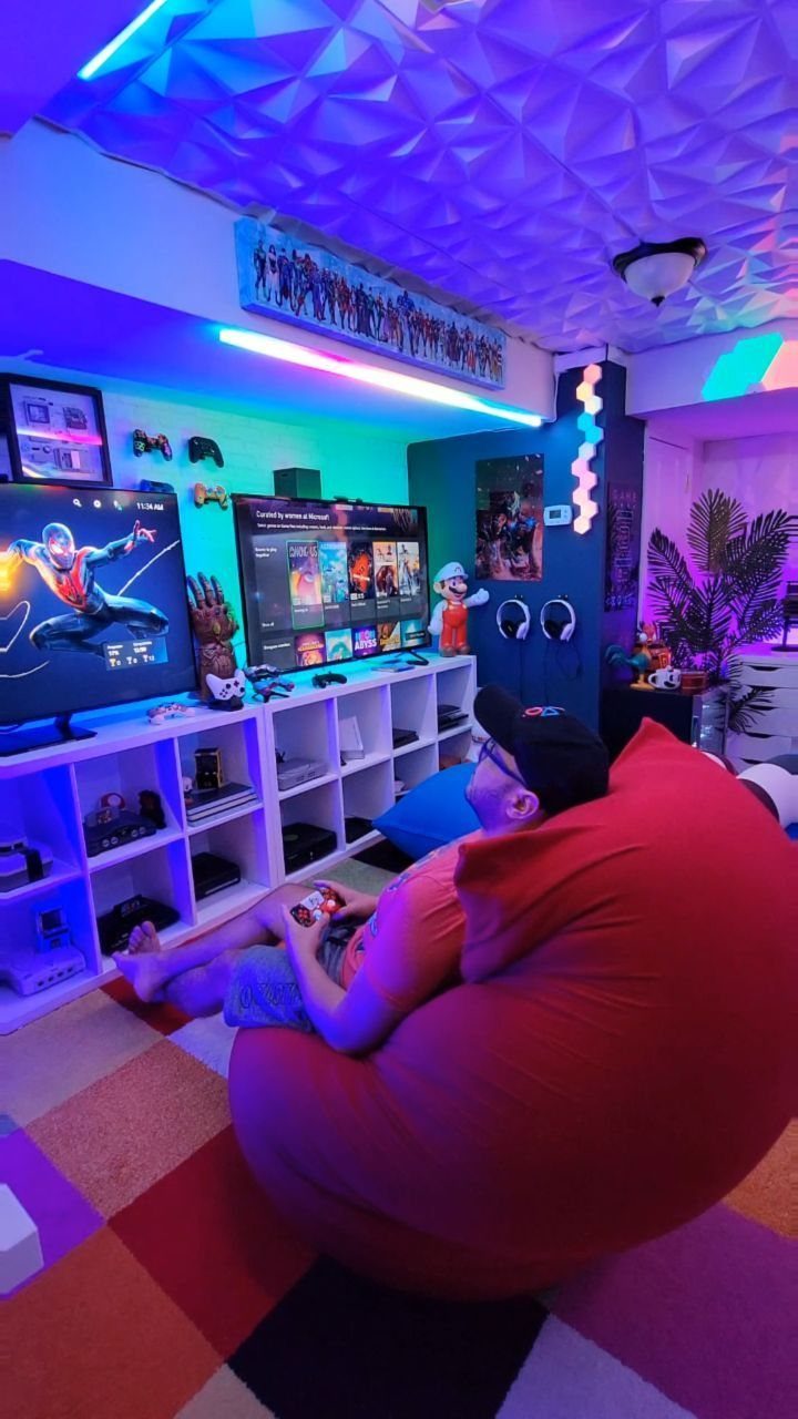 Person sitting in a red bean bag chair in a neon-lit gaming room.