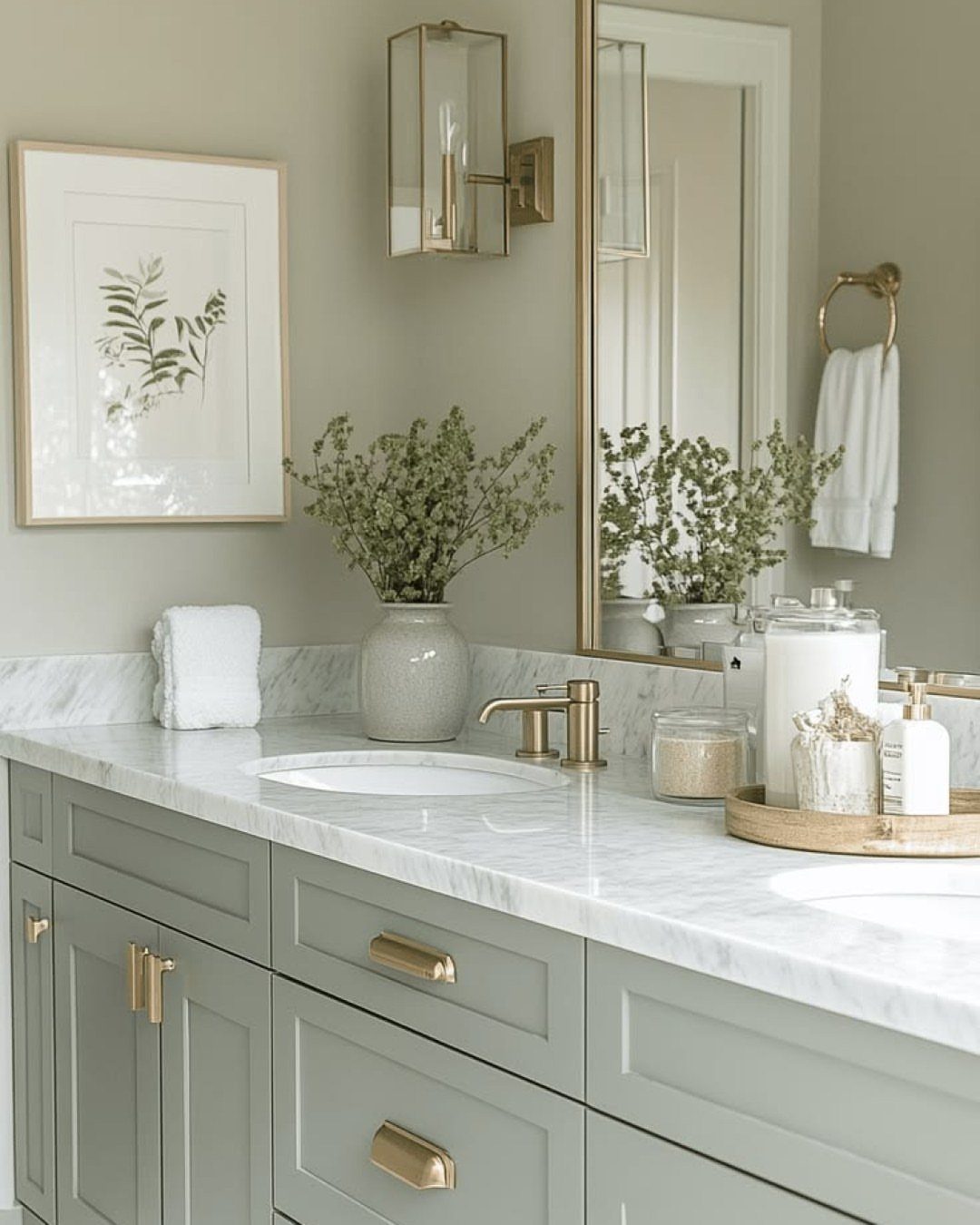Sage green bathroom vanity with gold hardware and a white marble countertop.
