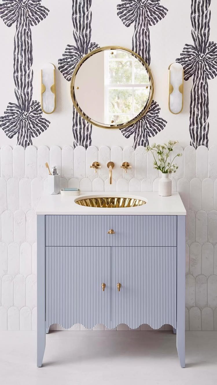 Light blue furniture-style vanity with gold sink and purple bow wallpaper background.