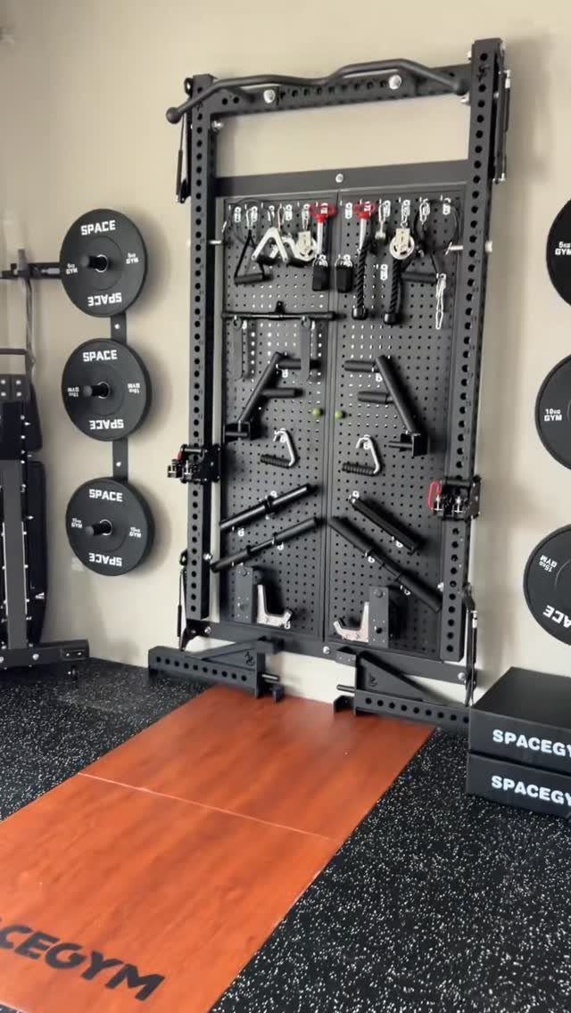 Wall-mounted power rack with weight plates and gym mats in a home gym