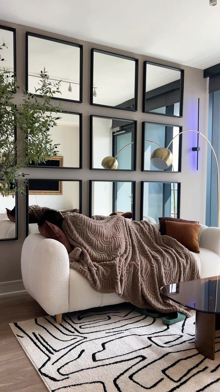 White sofa with brown throw blanket and pillows in a cozy living room