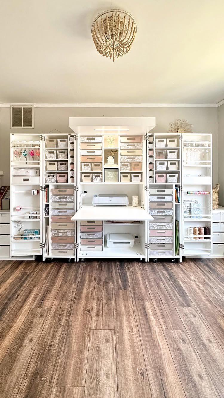 White craft storage unit with integrated desk on brown wood flooring under a chandelier