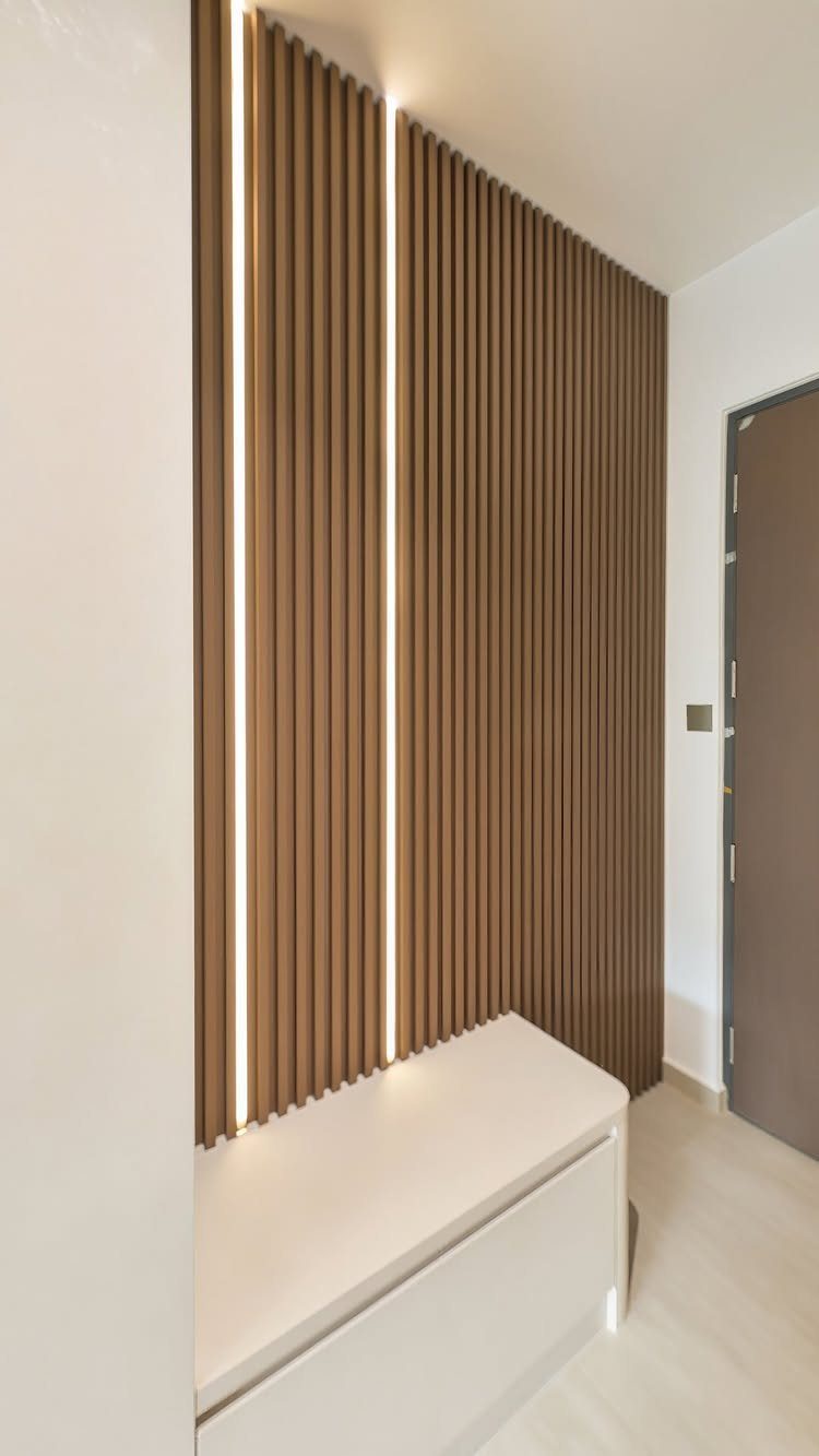 Brown vertical wooden slat wall with integrated LED lighting and a white bench.