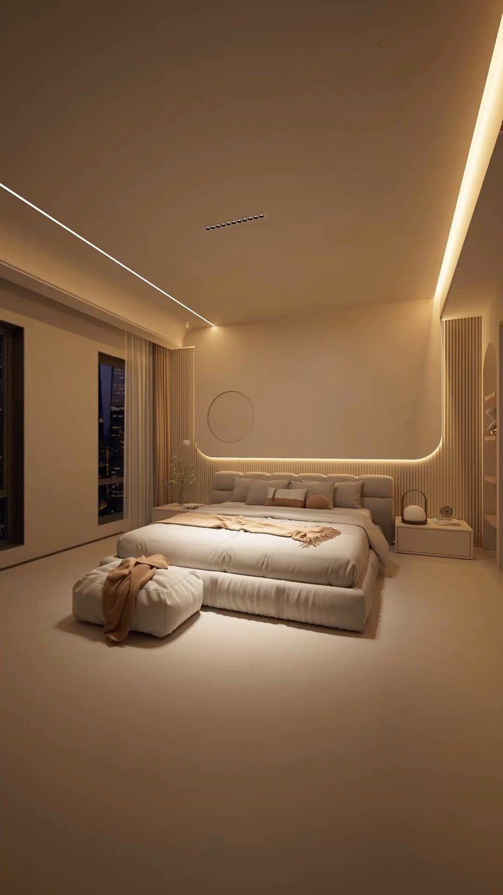 Minimalist bedroom with beige bedding and warm recessed lighting overlooking a city skyline.