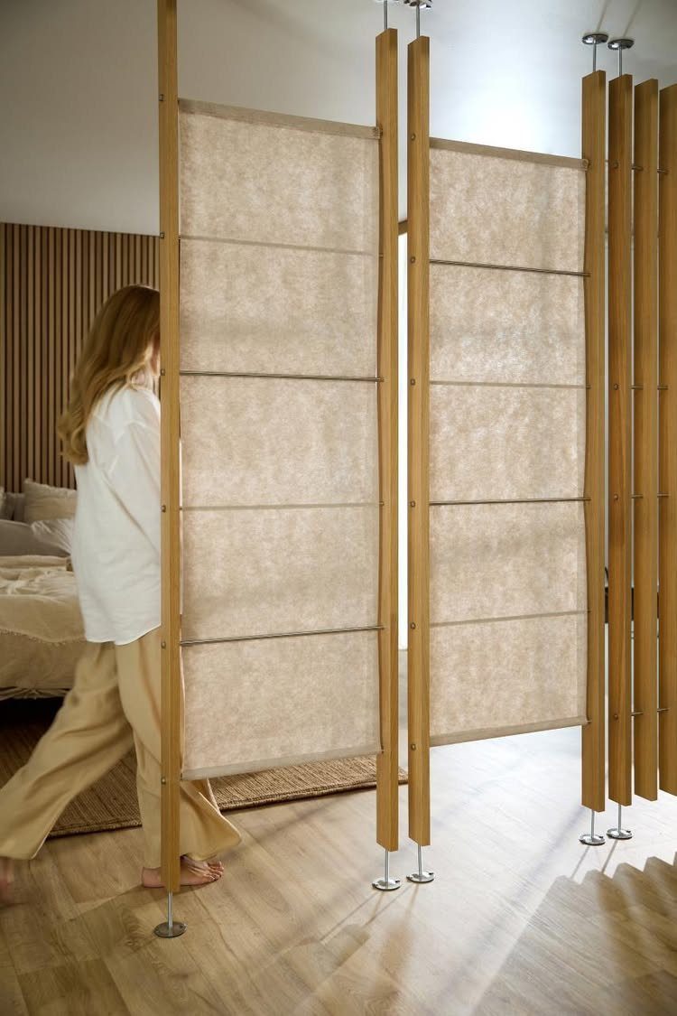 Sliding fabric and wood room dividers separating spaces in a modern light-filled apartment.