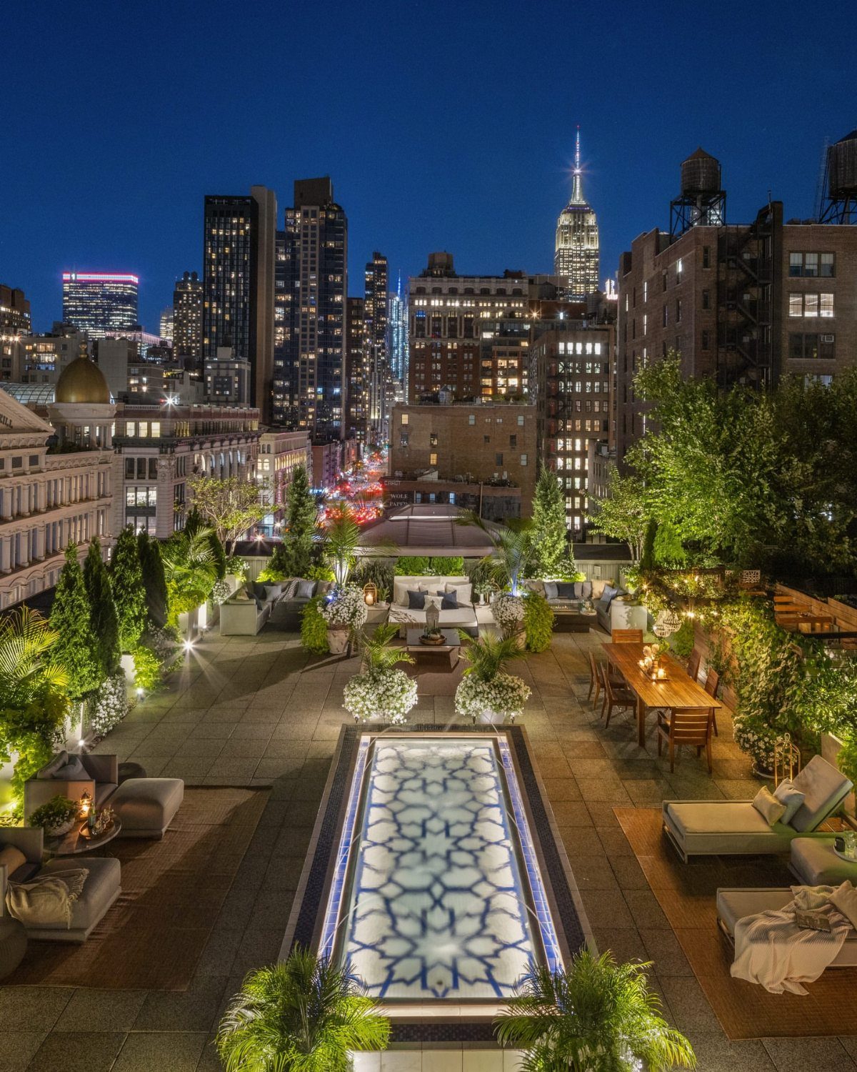 Luxury rooftop terrace with a pool overlooking the New York City night skyline.