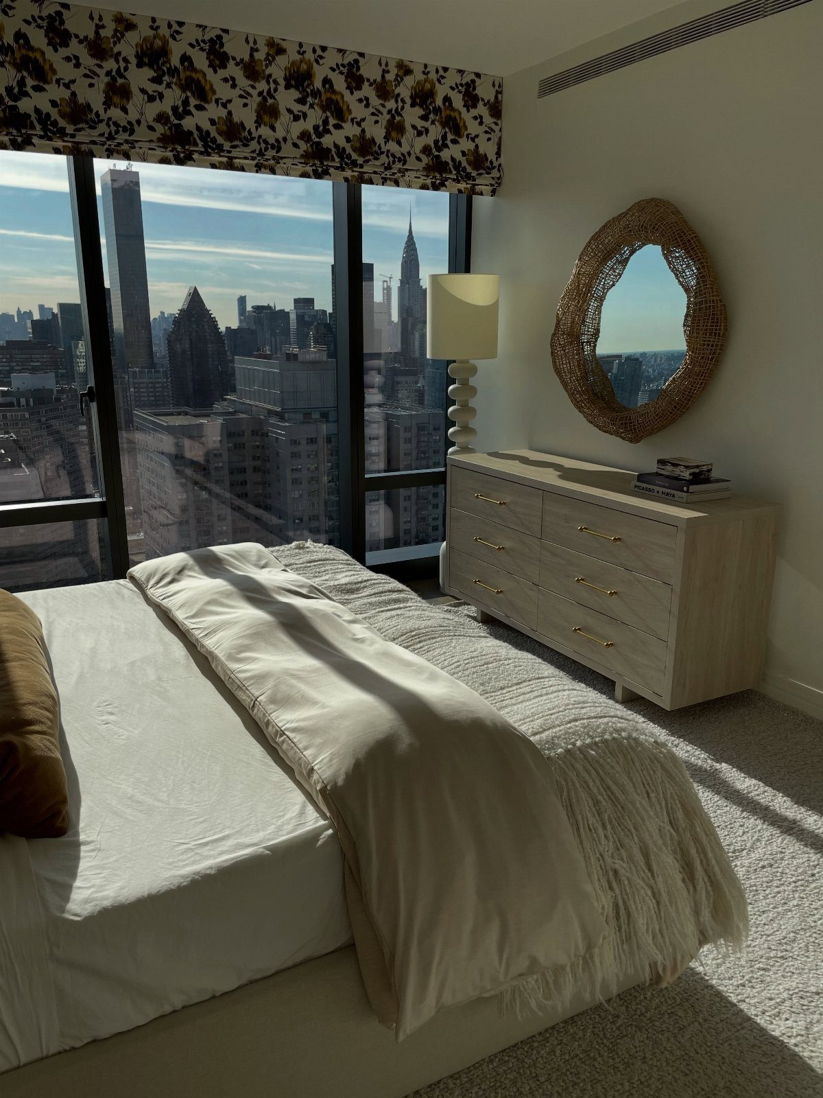 Bedroom interior with a large window overlooking the New York City skyline
