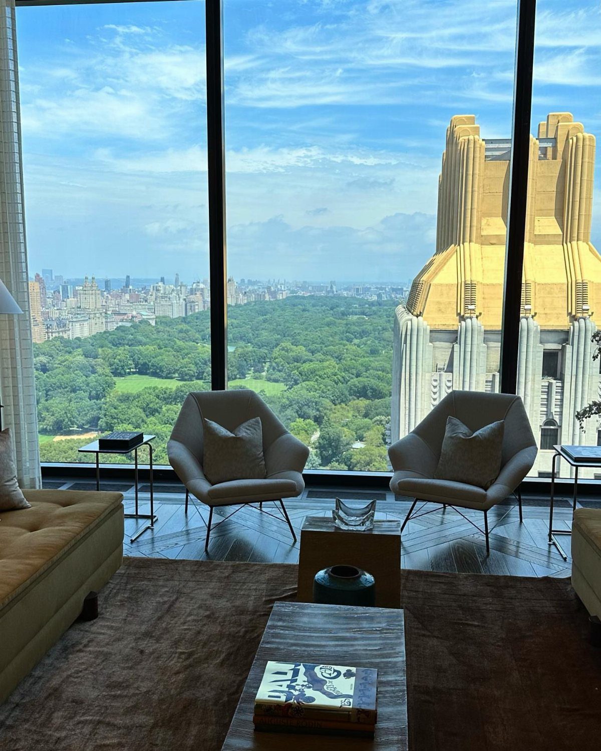 Modern living room with white chairs overlooking Central Park and New York skyline