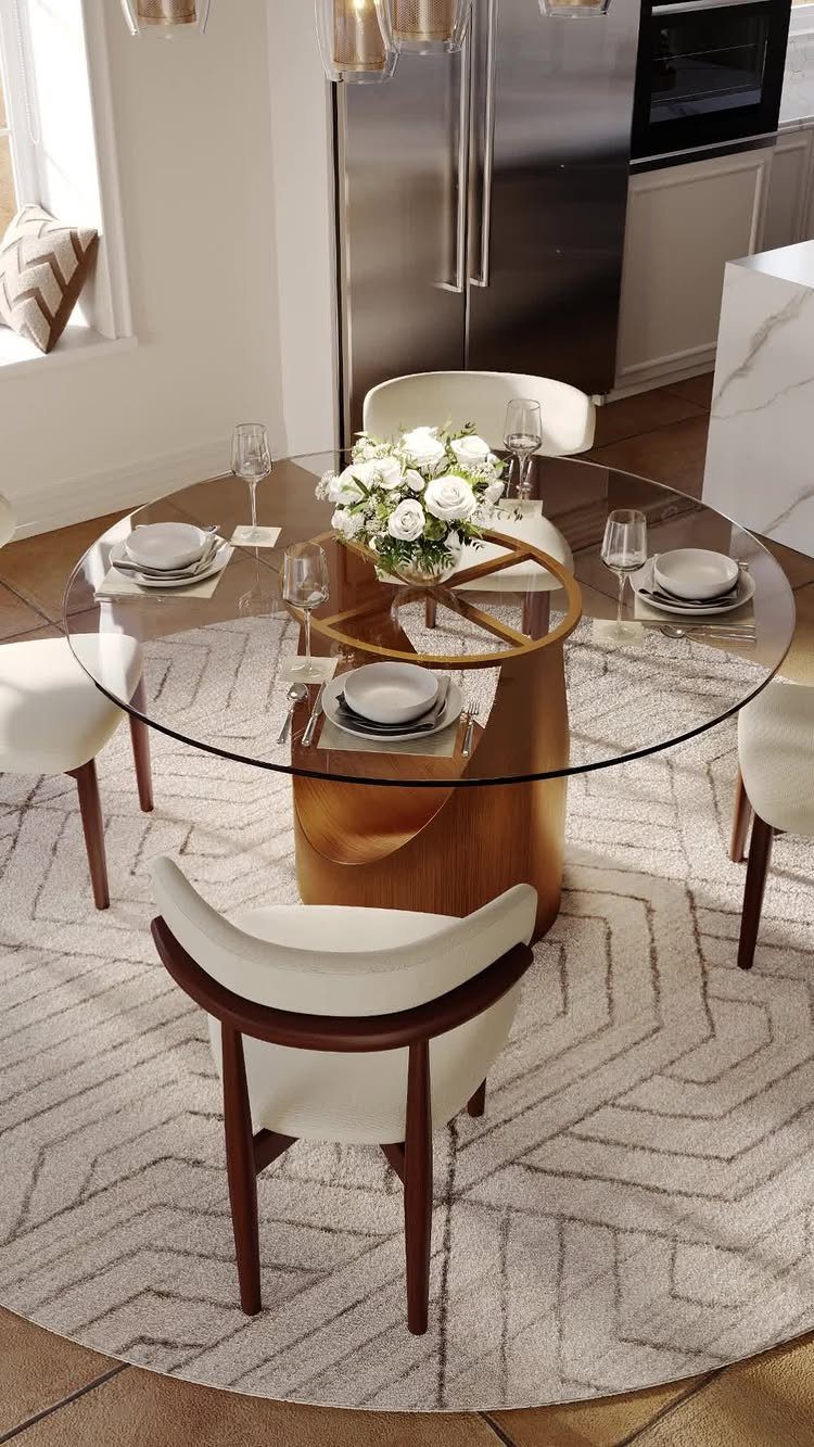 Round glass dining table with white chairs on a grey patterned circular rug.