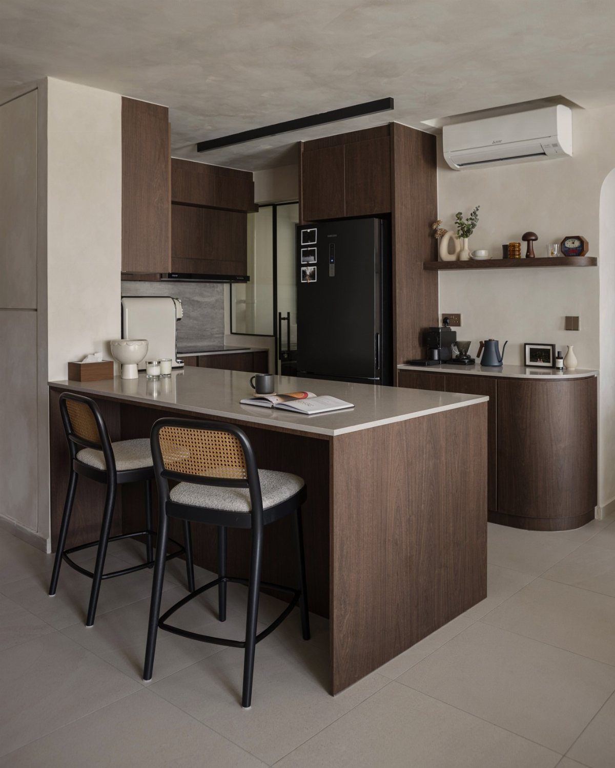 Kitchen island with two bar stools replacing a traditional dining table in a studio.