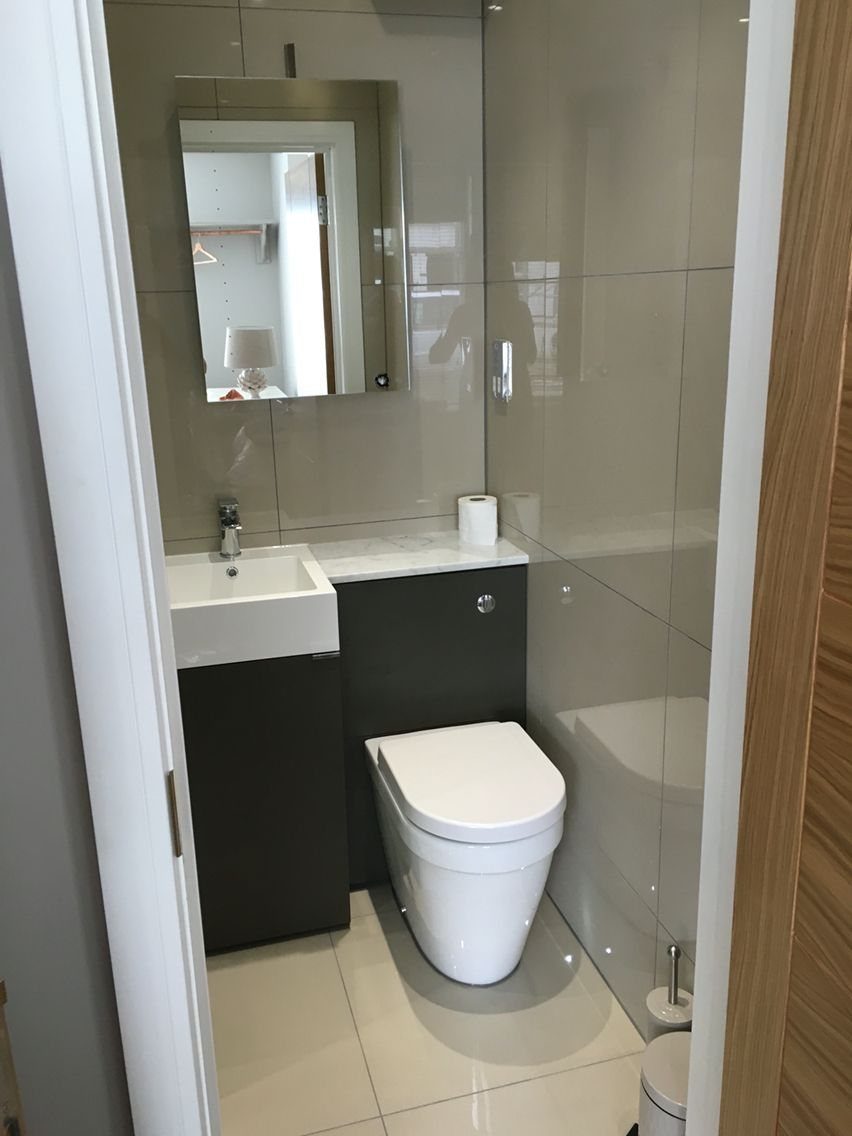 Small bathroom featuring dark grey cabinetry under a white sink and toilet.