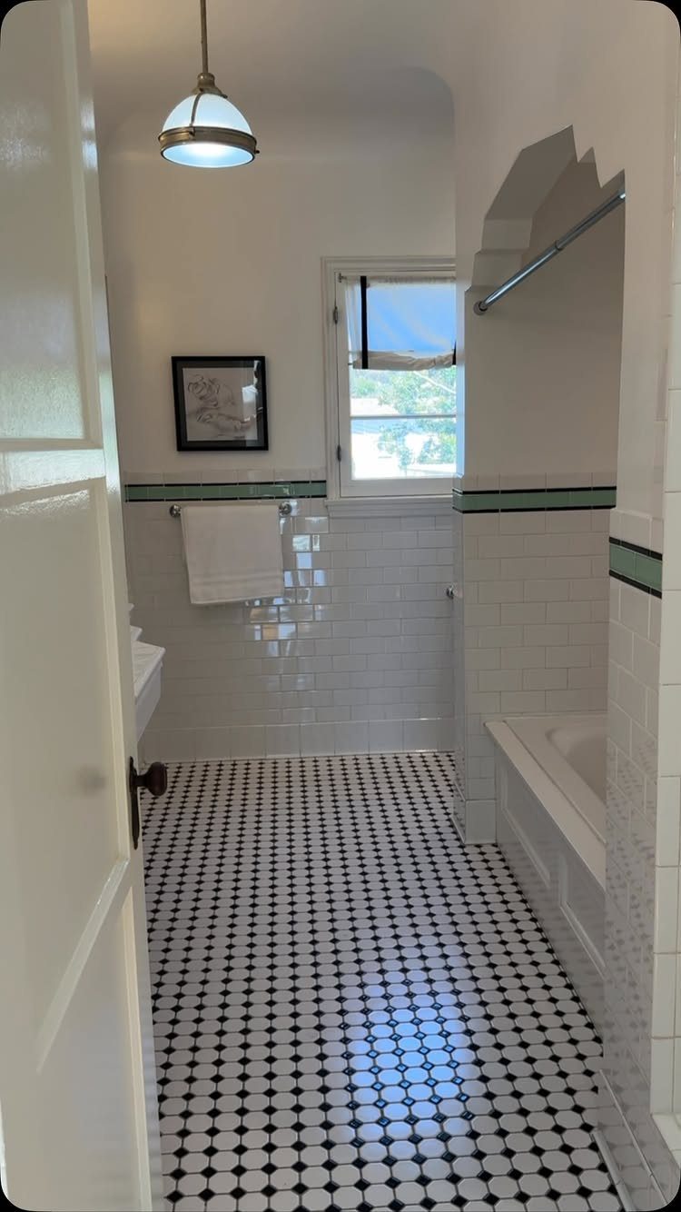 White subway tiles on bathroom walls with black and white patterned floor tiles.