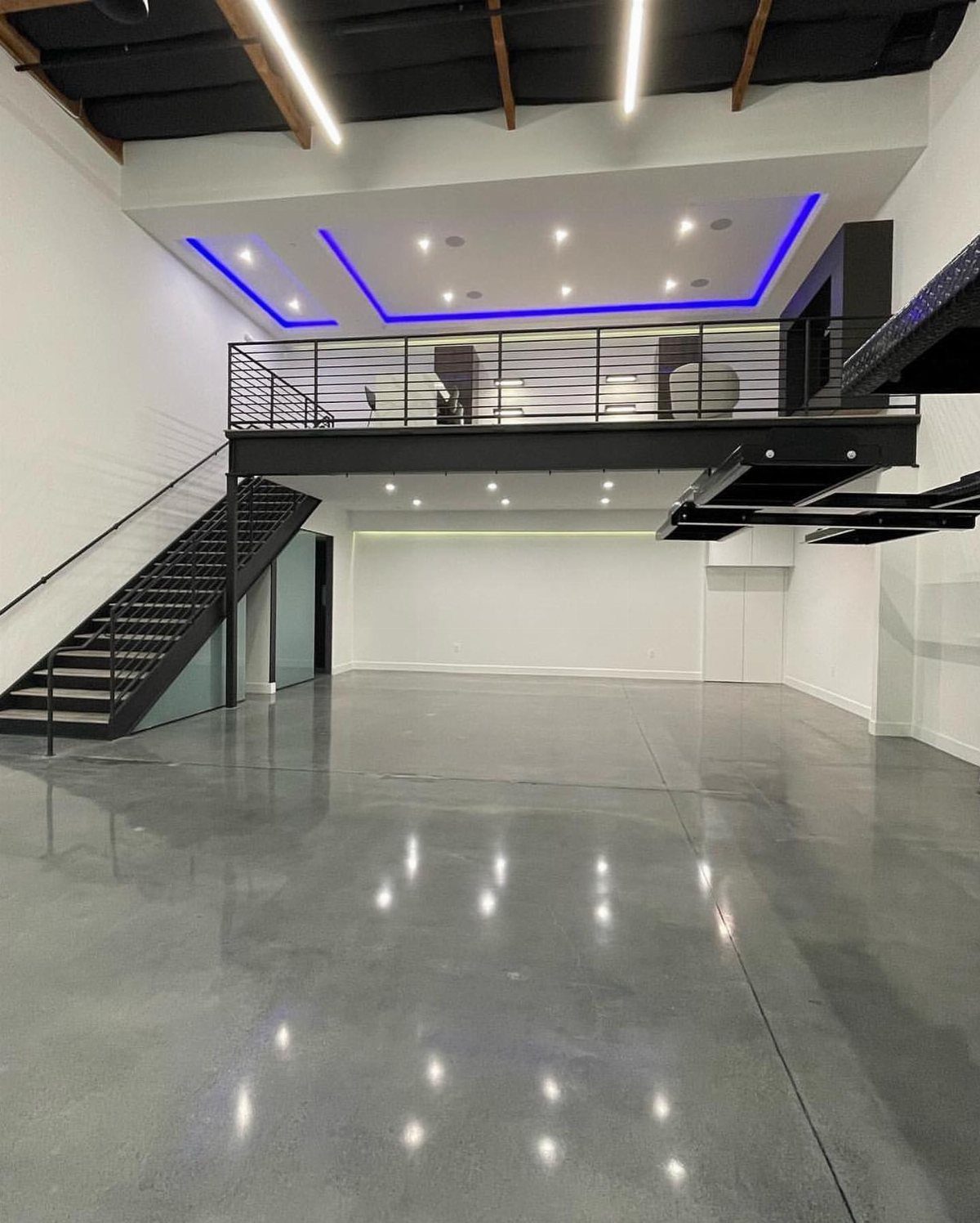 Modern garage interior with polished concrete floors and a lofted mezzanine area.