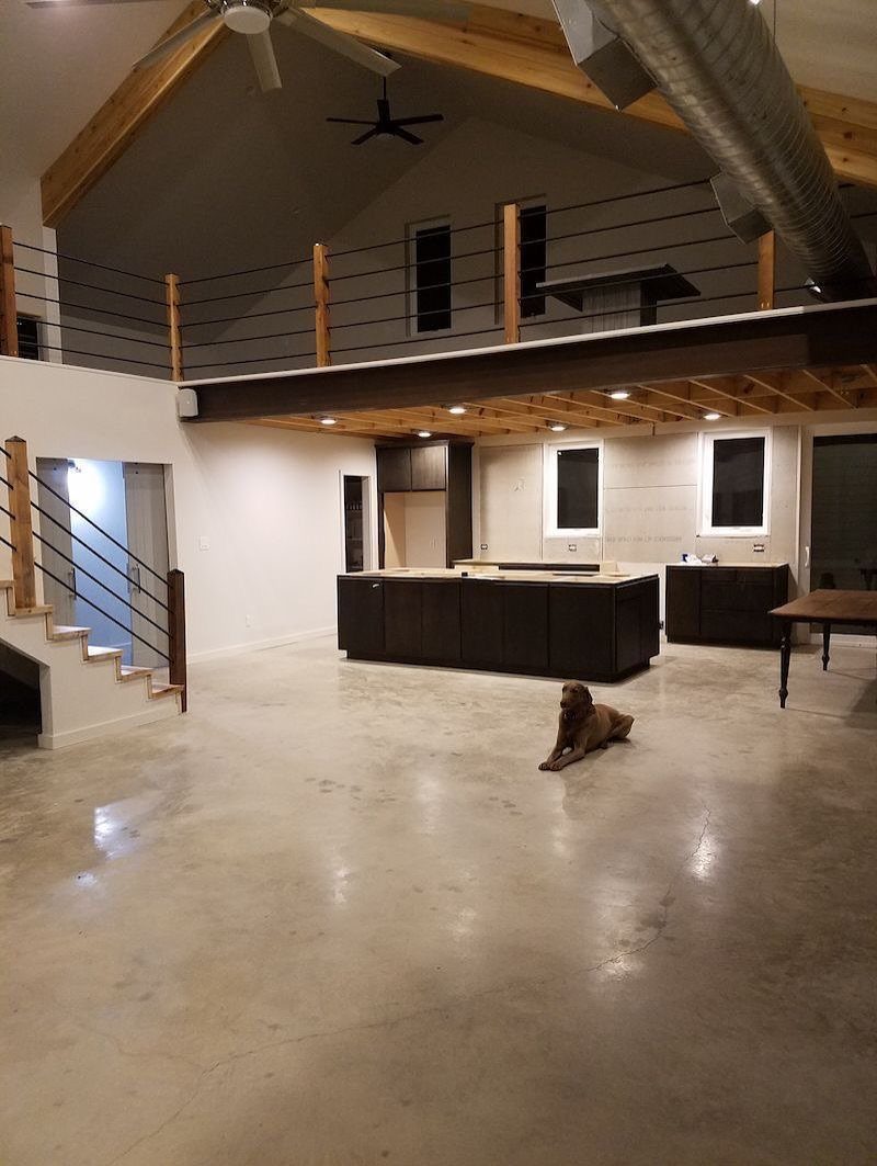 Open interior of a pole barn garage featuring a loft and kitchen area.