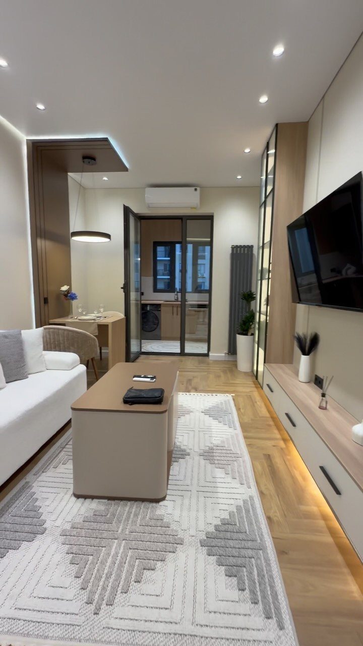 Modern living room featuring layered lighting with recessed ceiling lights and under-cabinet LEDs.