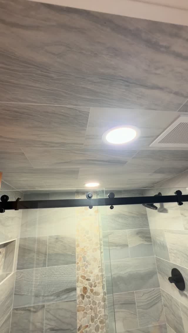 Grey marbled tiles covering both the shower walls and the bathroom ceiling.