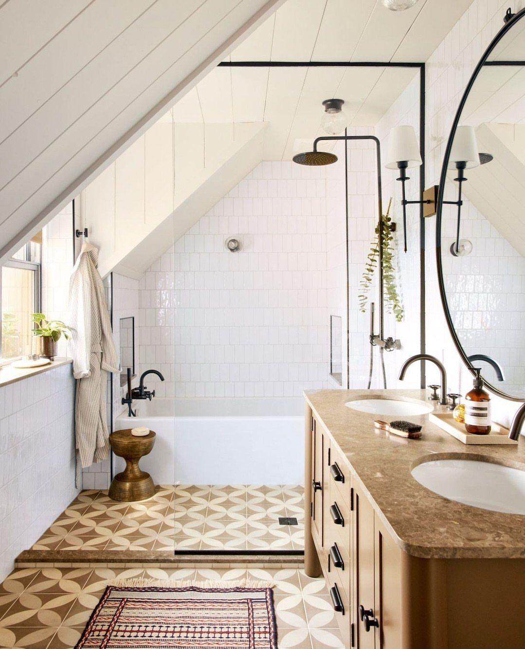 White tiled bathroom wall reaching the sloped ceiling above a white bathtub.