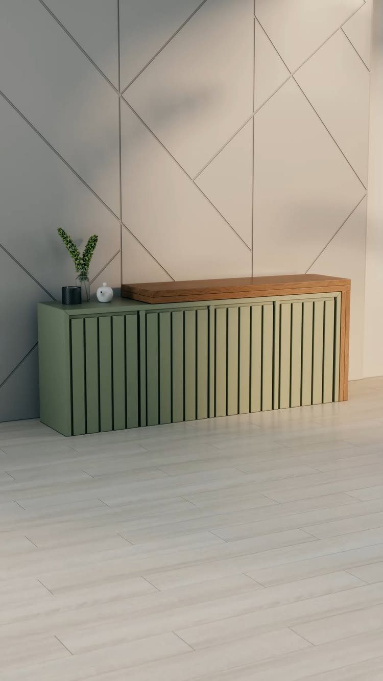 Green slatted storage cabinet with wooden top against a geometric grey wall.
